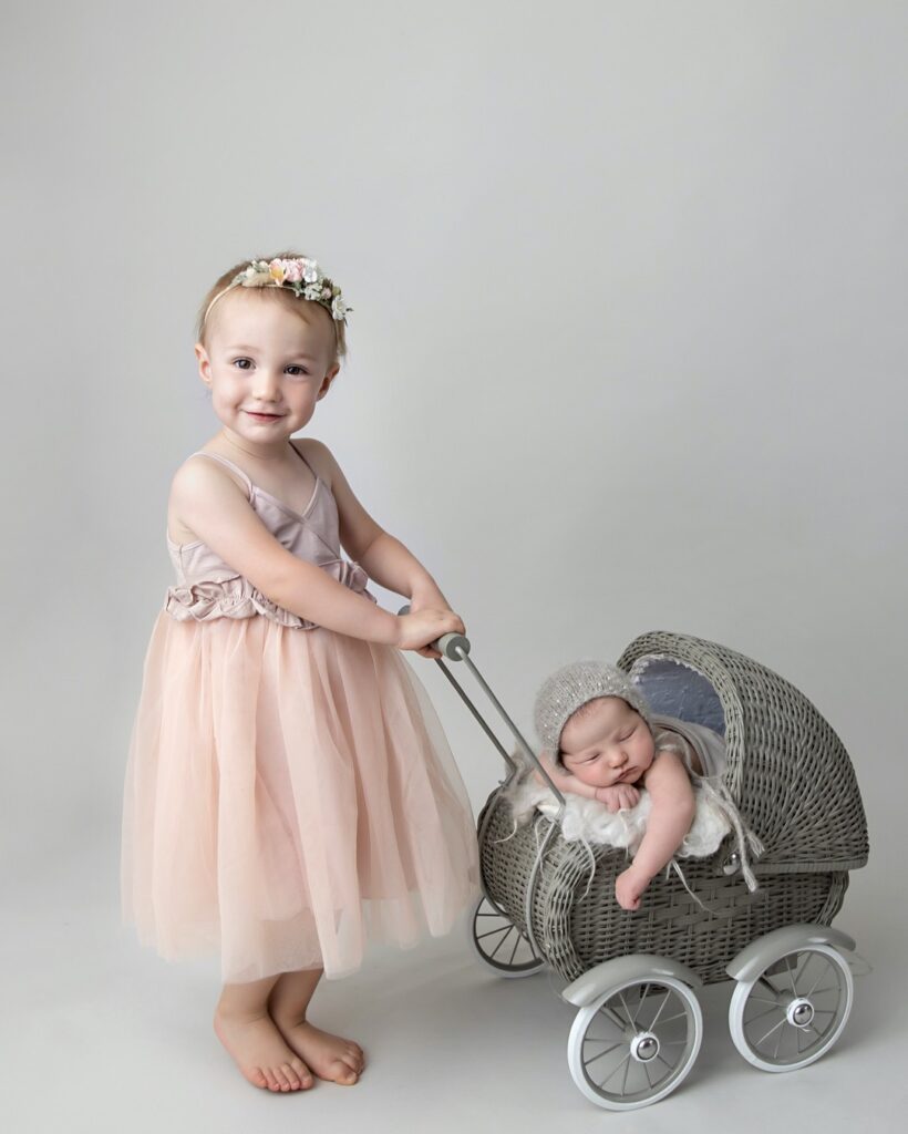 Big sister with baby in carriage.  Hewitt Newborn Photographer
